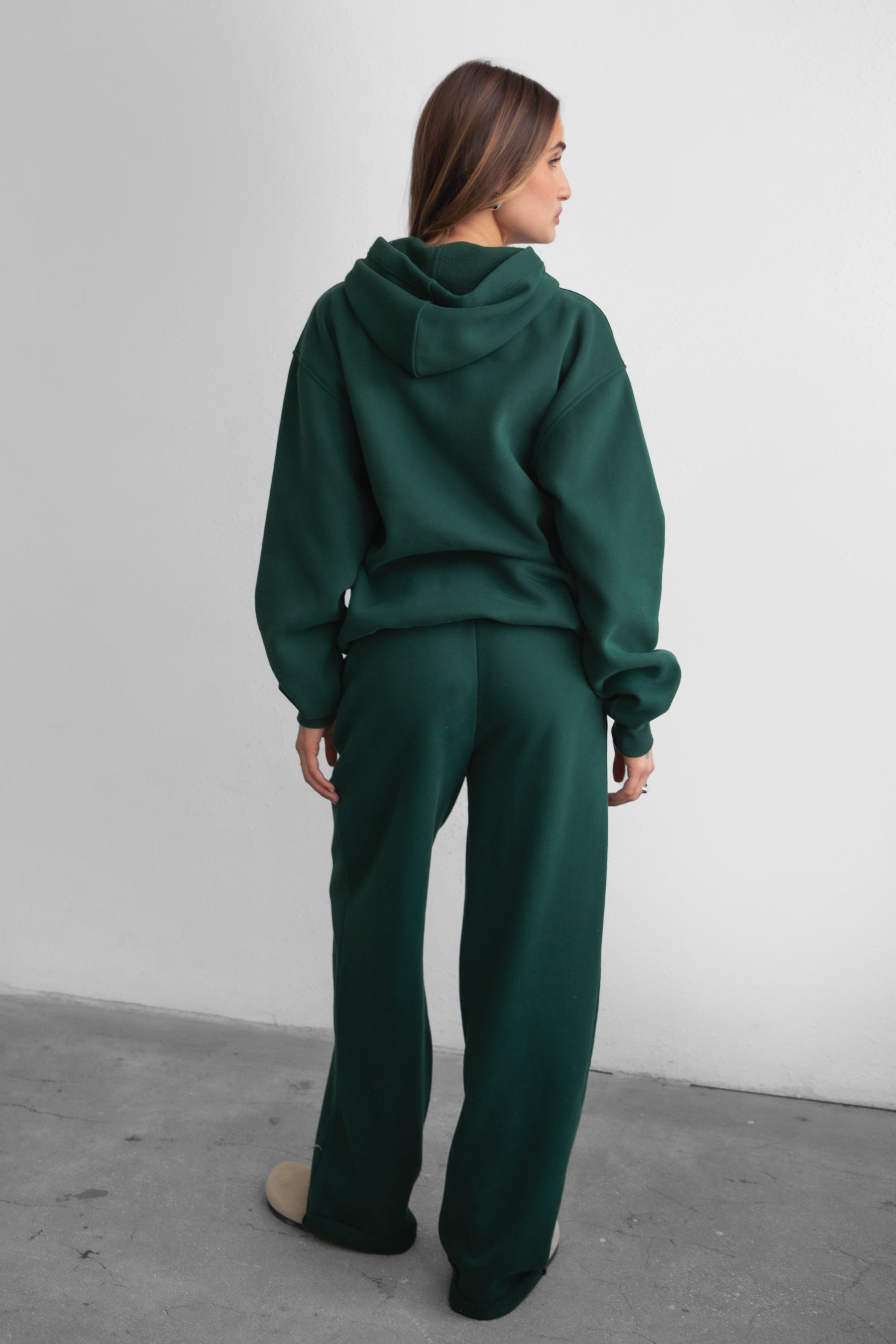 Woman wearing the TIC TOC PJ30241 LANI forrest green cloud fleece wide leg sweatpants featuring a straight leg silhouette, drawcord waistband, and side pockets paired with a matching hoodie. 