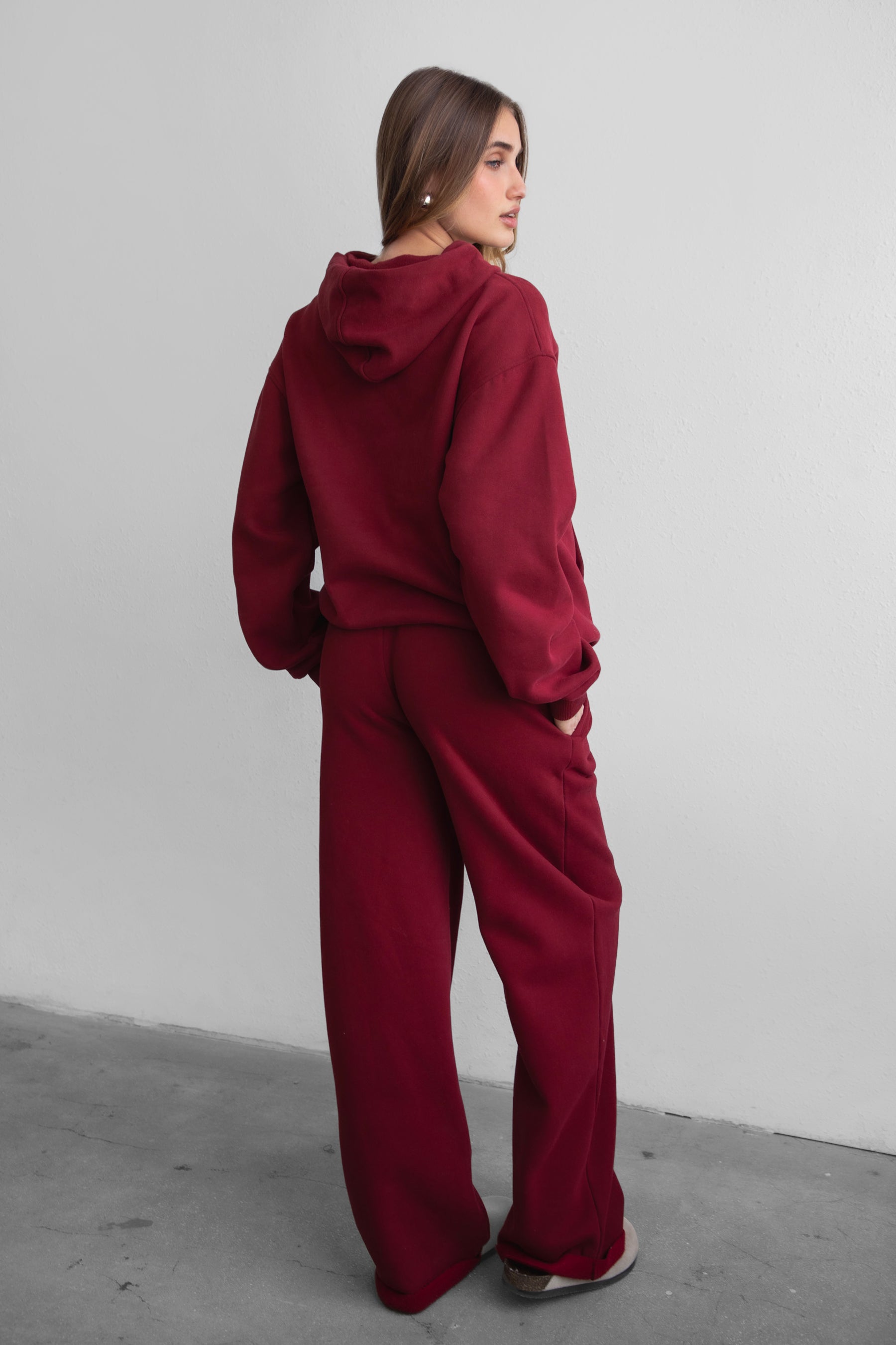 Woman wearing the TIC TOC PJ30241 LANI maroon cloud fleece wide leg sweatpants featuring a straight leg silhouette, drawcord waistband, and side pockets paired with a matching hoodie. 