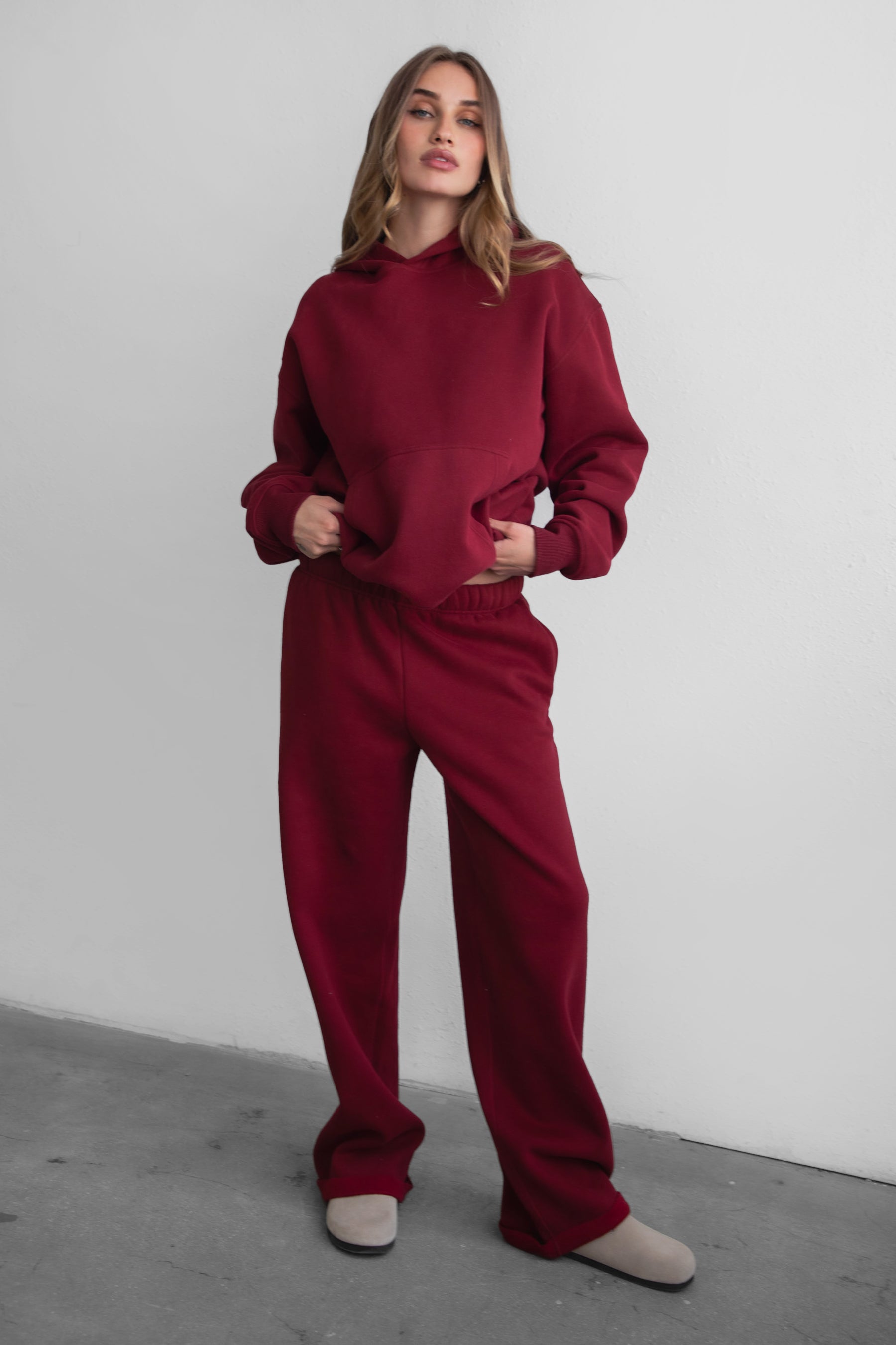 Woman wearing the TIC TOC PJ30241 LANI maroon cloud fleece wide leg sweatpants featuring a straight leg silhouette, drawcord waistband, and side pockets paired with a matching hoodie. 