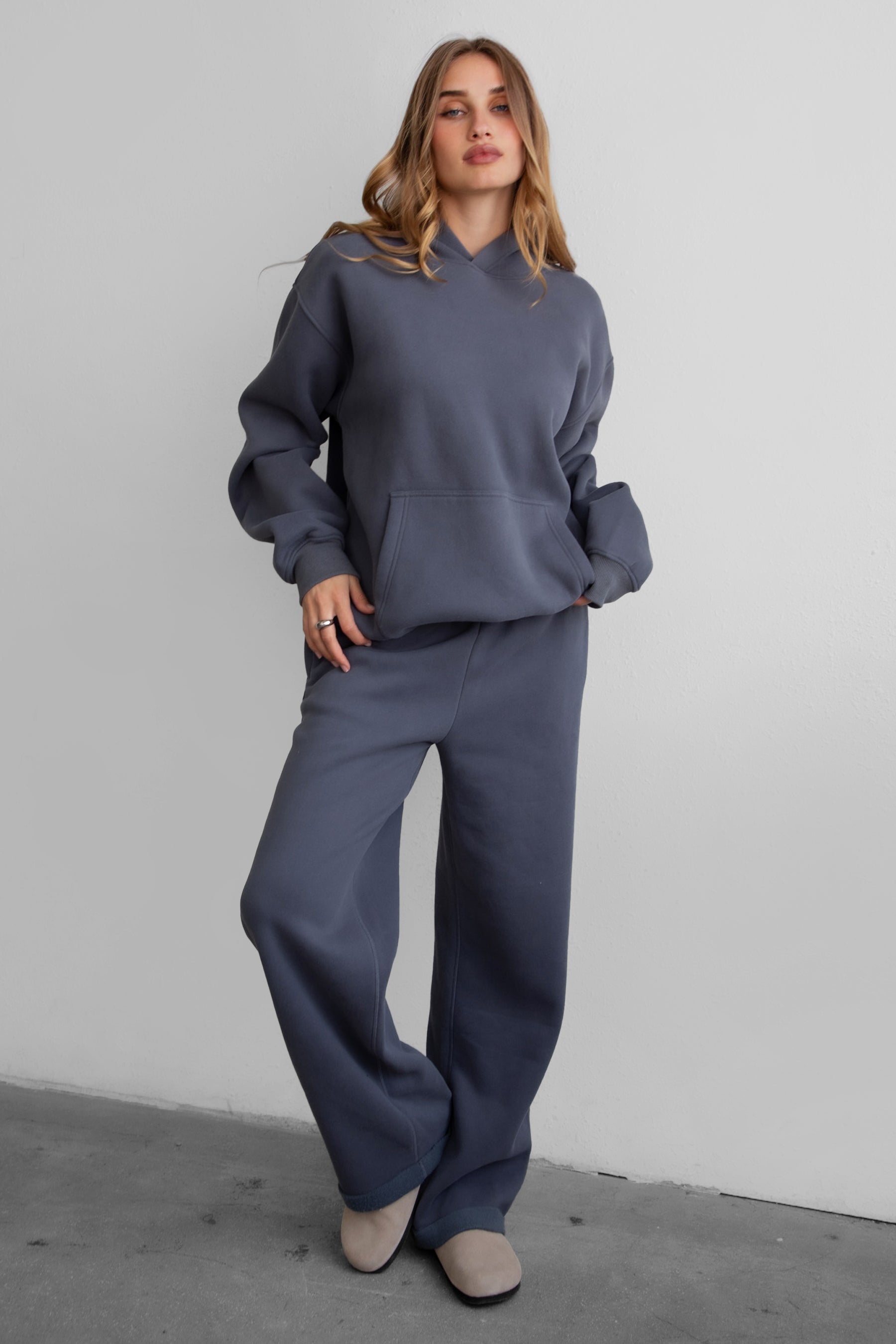 Woman wearing the TIC TOC PJ30241 LANI steel grey cloud fleece wide leg sweatpants featuring a straight leg silhouette, drawcord waistband, and side pockets paired with a matching hoodie. 