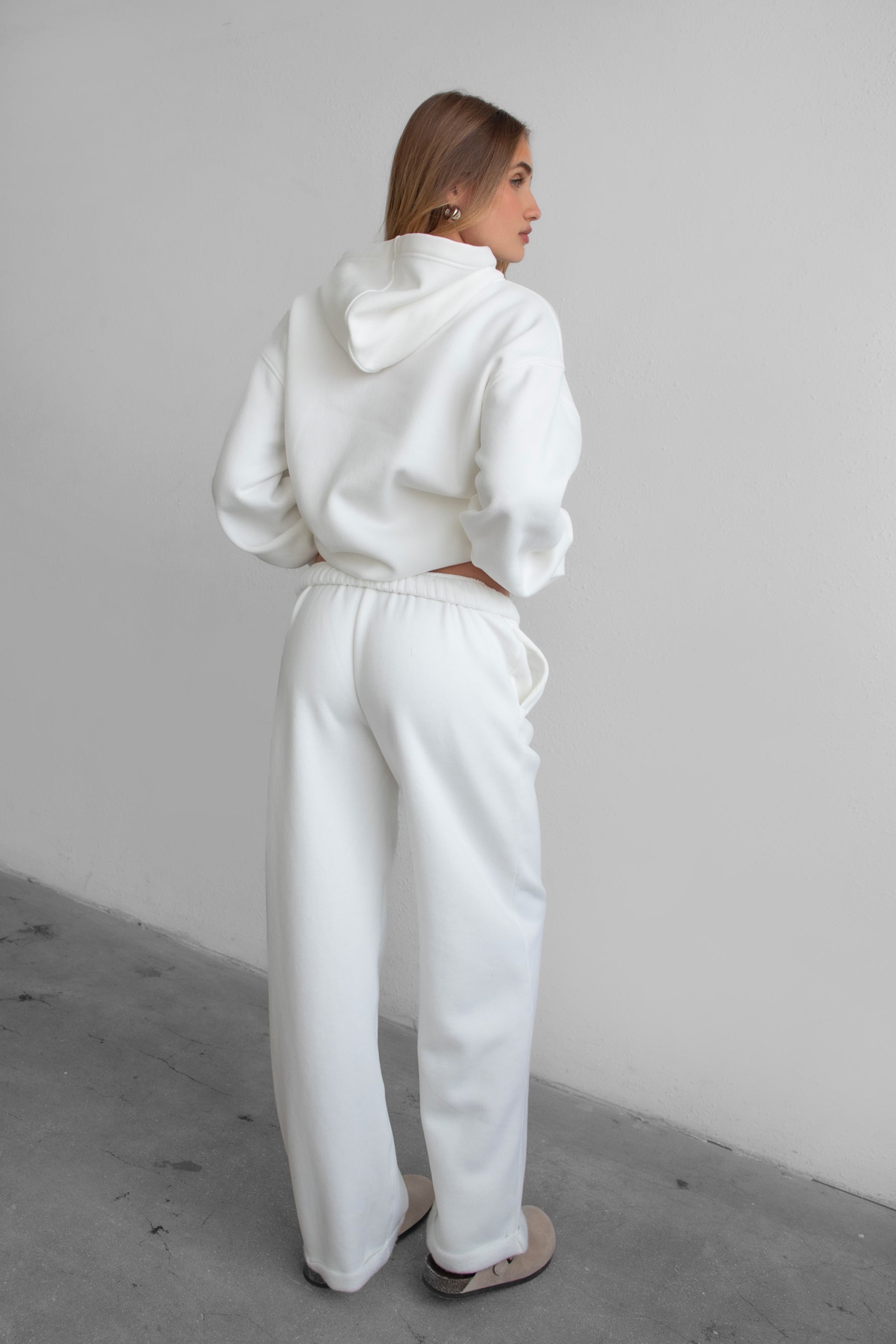 Woman wearing the TIC TOC PJ30241 LANI white cloud fleece wide leg sweatpants featuring a straight leg silhouette, drawcord waistband, and side pockets paired with a matching hoodie. 