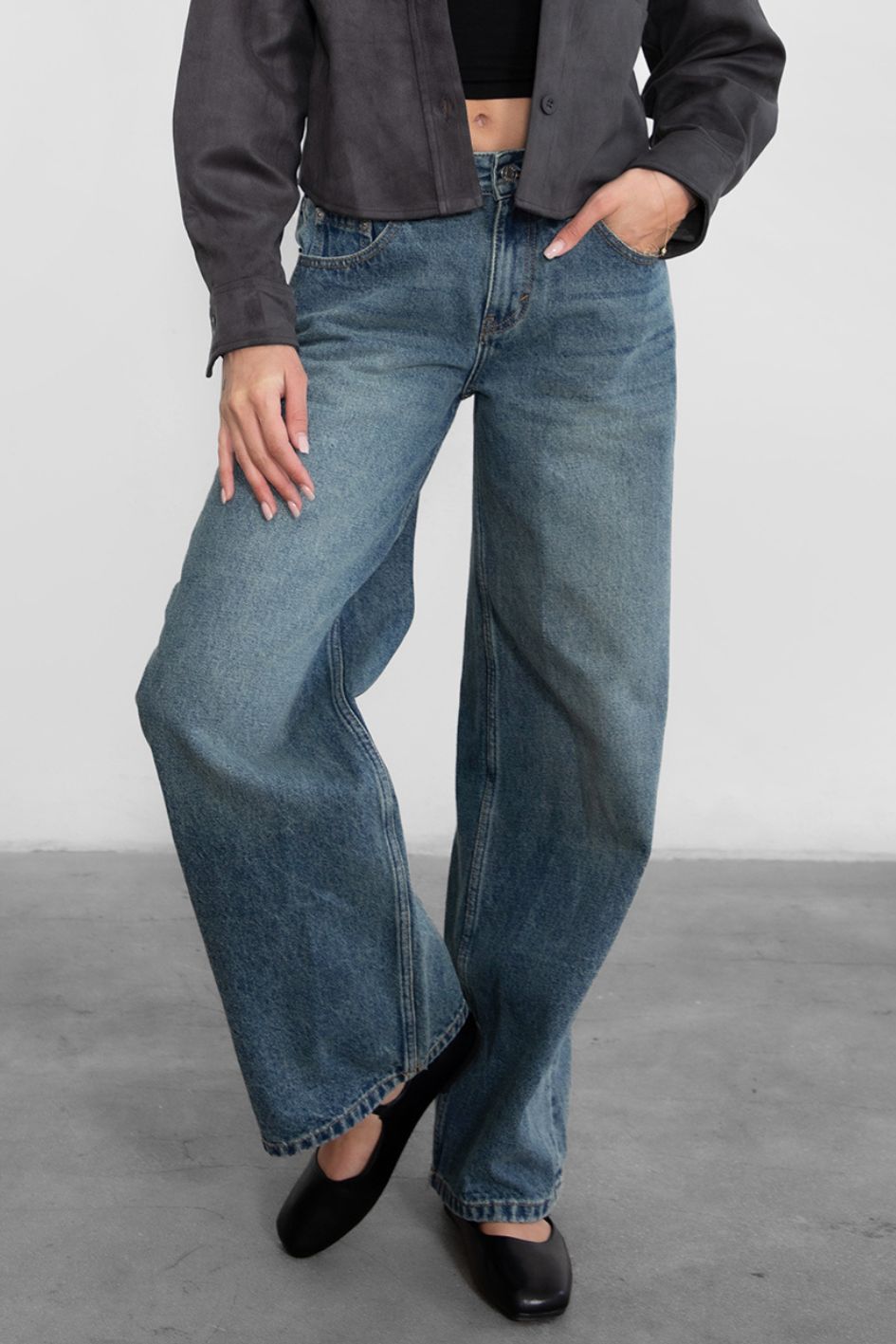 Woman wearing TIC TOC PJ30350 WINSLEY low rise straight leg denim jeans in vintage blue wash with wide leg fit paired a grey shacket and flats. 