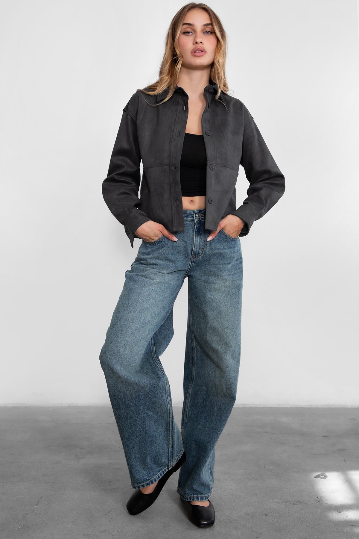 Woman wearing TIC TOC PJ30350 WINSLEY low rise straight leg denim jeans in vintage blue wash with wide leg fit paired a grey shacket and flats. 