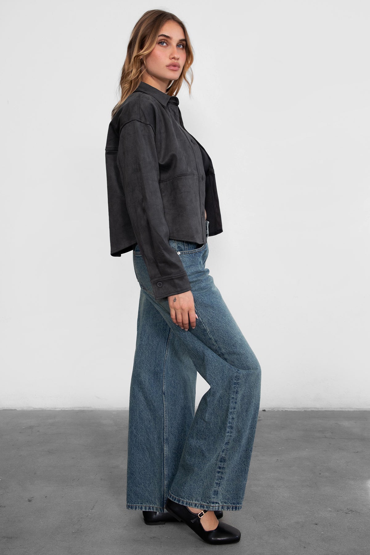 Woman wearing TIC TOC PJ30350 WINSLEY low rise straight leg denim jeans in vintage blue wash with wide leg fit paired a grey shacket and flats. 