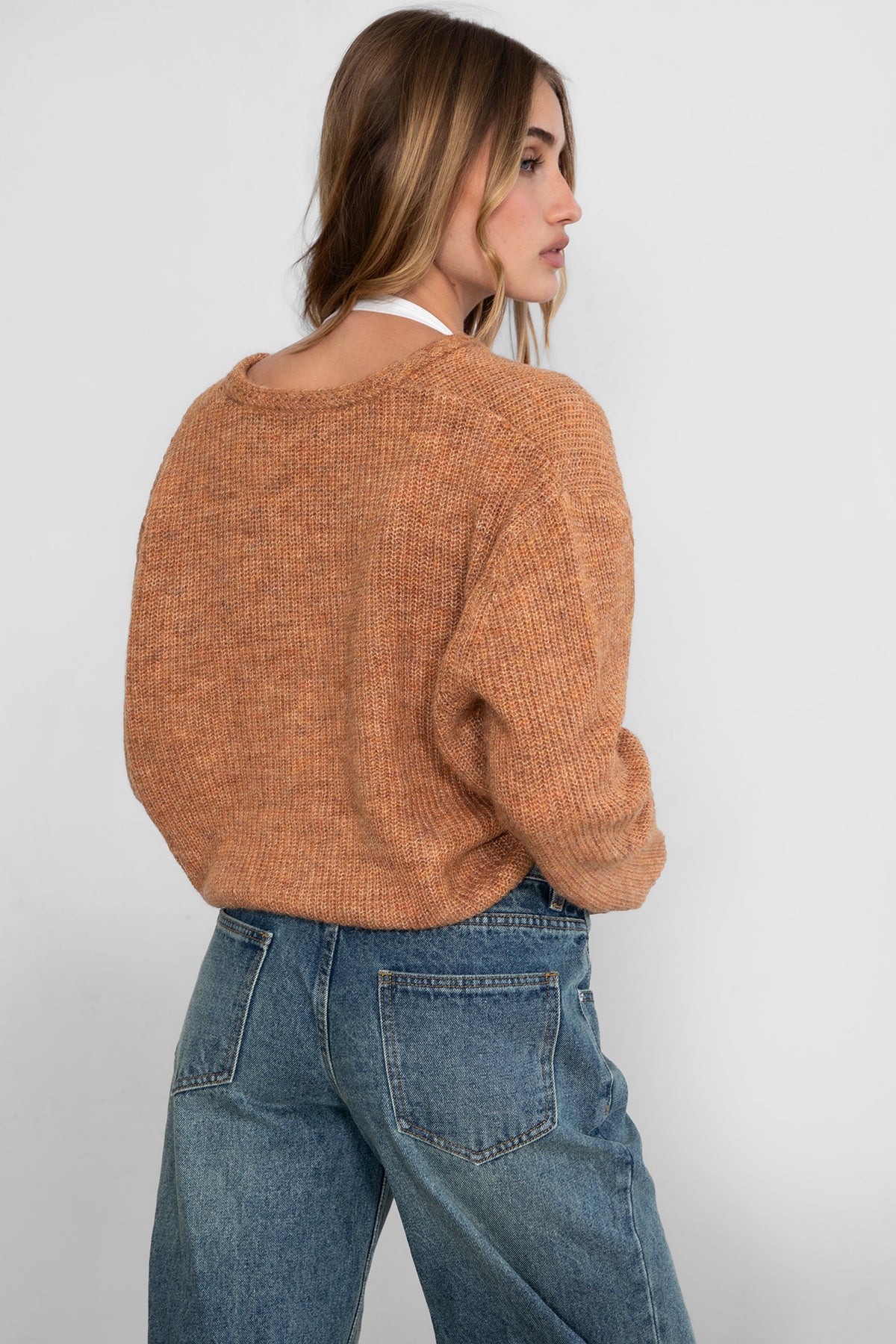 Woman wearing TIC TOC TC29311 CURTY marled cropped knit cardigan with button up front and double pocket detail paired with dark denim