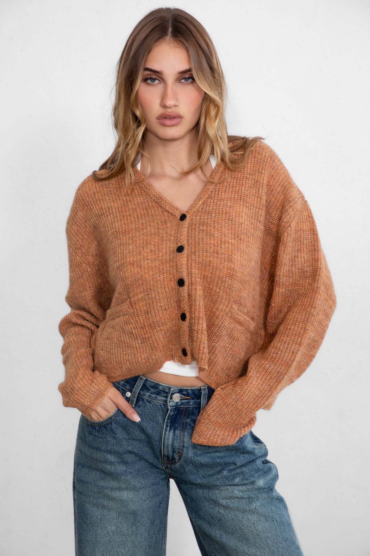 Woman wearing TIC TOC TC29311 CURTY marled cropped knit cardigan with button up front and double pocket detail paired with dark denim