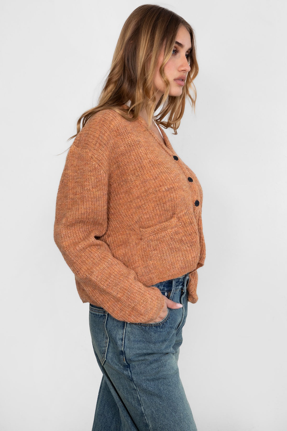 Woman wearing TIC TOC TC29311 CURTY marled cropped knit cardigan with button up front and double pocket detail paired with dark denim