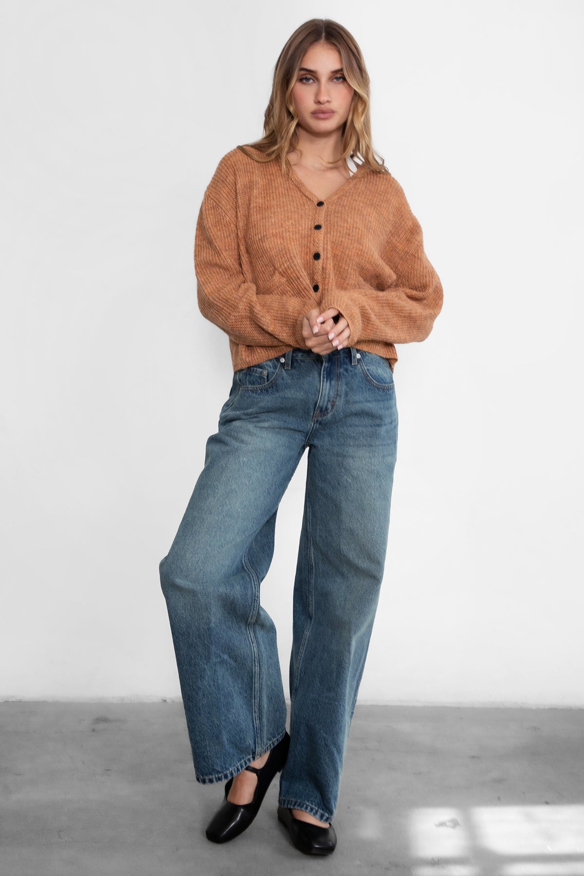 Woman wearing TIC TOC TC29311 CURTY marled cropped knit cardigan with button up front and double pocket detail paired with dark denim