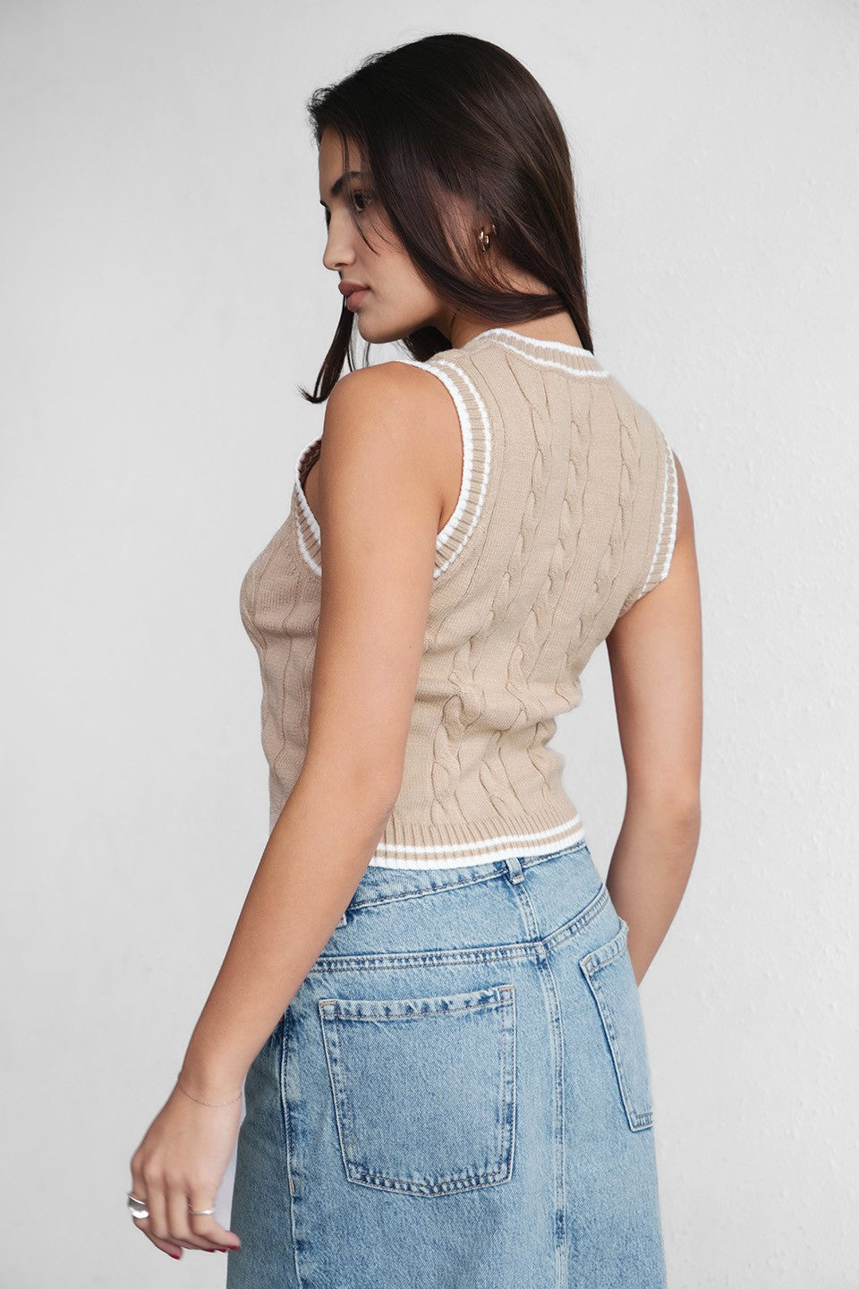 Woman wearing TIC TOC TC29858 WESTBRIDGE cable knit chunky vest with v neck and semi cropped length in classic ribbed hem design in color khaki paired with blue denim 