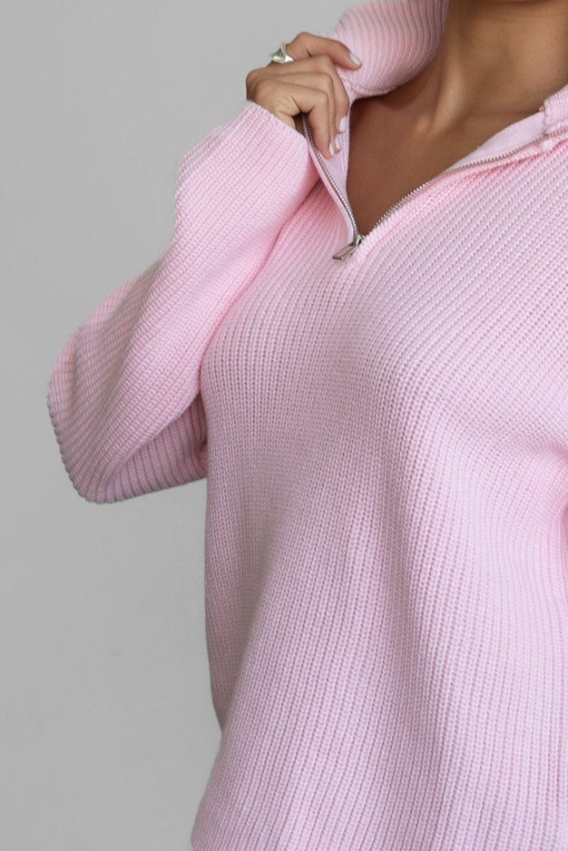 Woman wearing TIC TOC TC30699 LIISA oversized zip sweater with high mock collar and loose bell sleeves in cozy preppy style paired with blue denim shorts. 