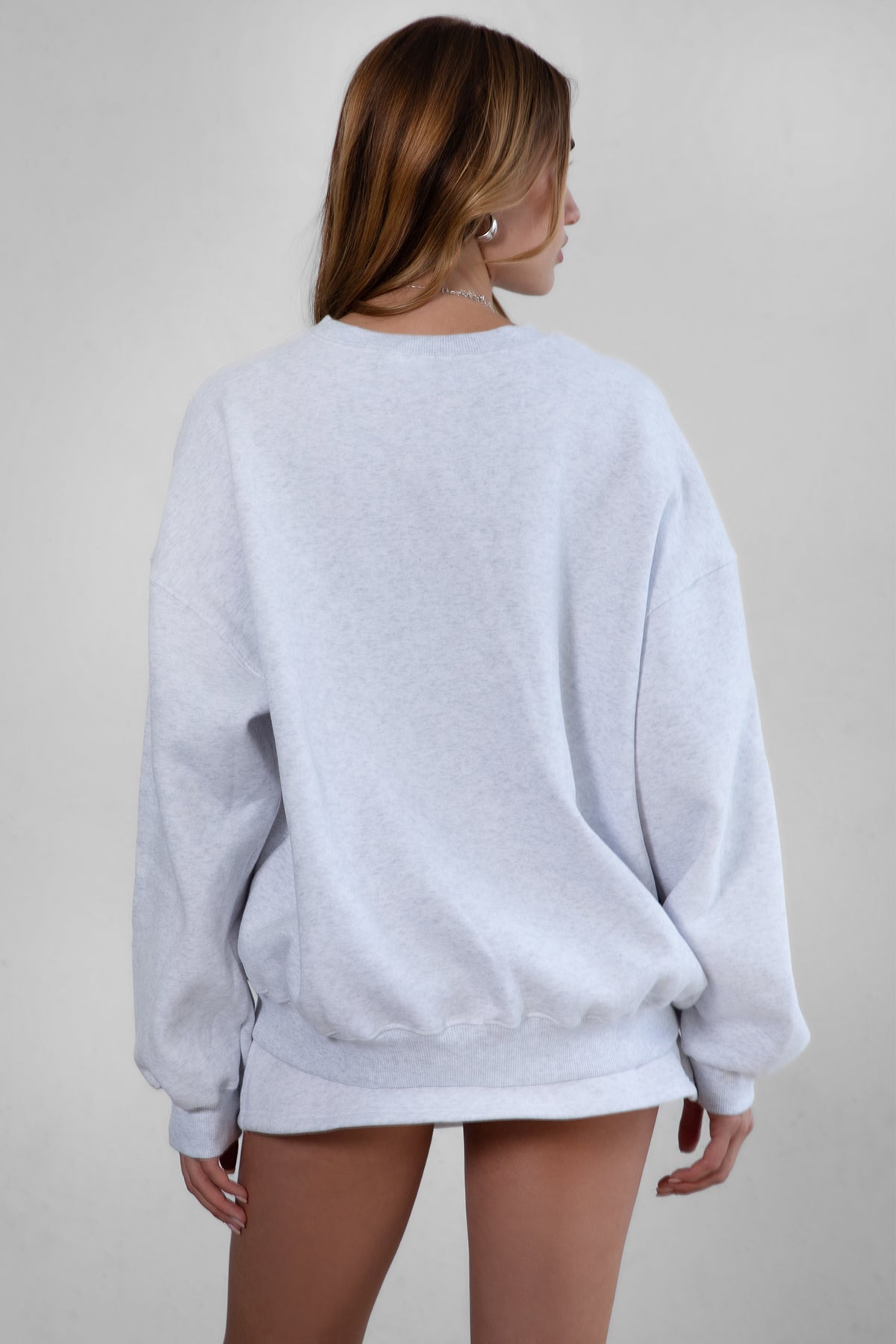 Woman wearing the TIC TOC TH28243 VARSITY ash fleece crew neck pullover sweatshirt featuring dropped shoulders, ribbed trim, and plush fleece fabric with the matching bottoms 