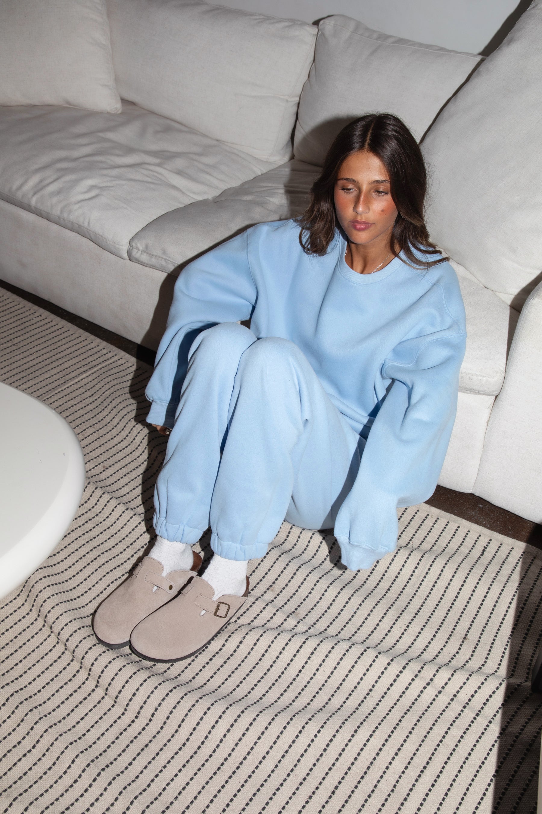 Woman wearing the TIC TOC TH28243 VARSITY baby blue fleece crew neck pullover sweatshirt featuring dropped shoulders, ribbed trim, and plush fleece fabric with the matching bottoms 