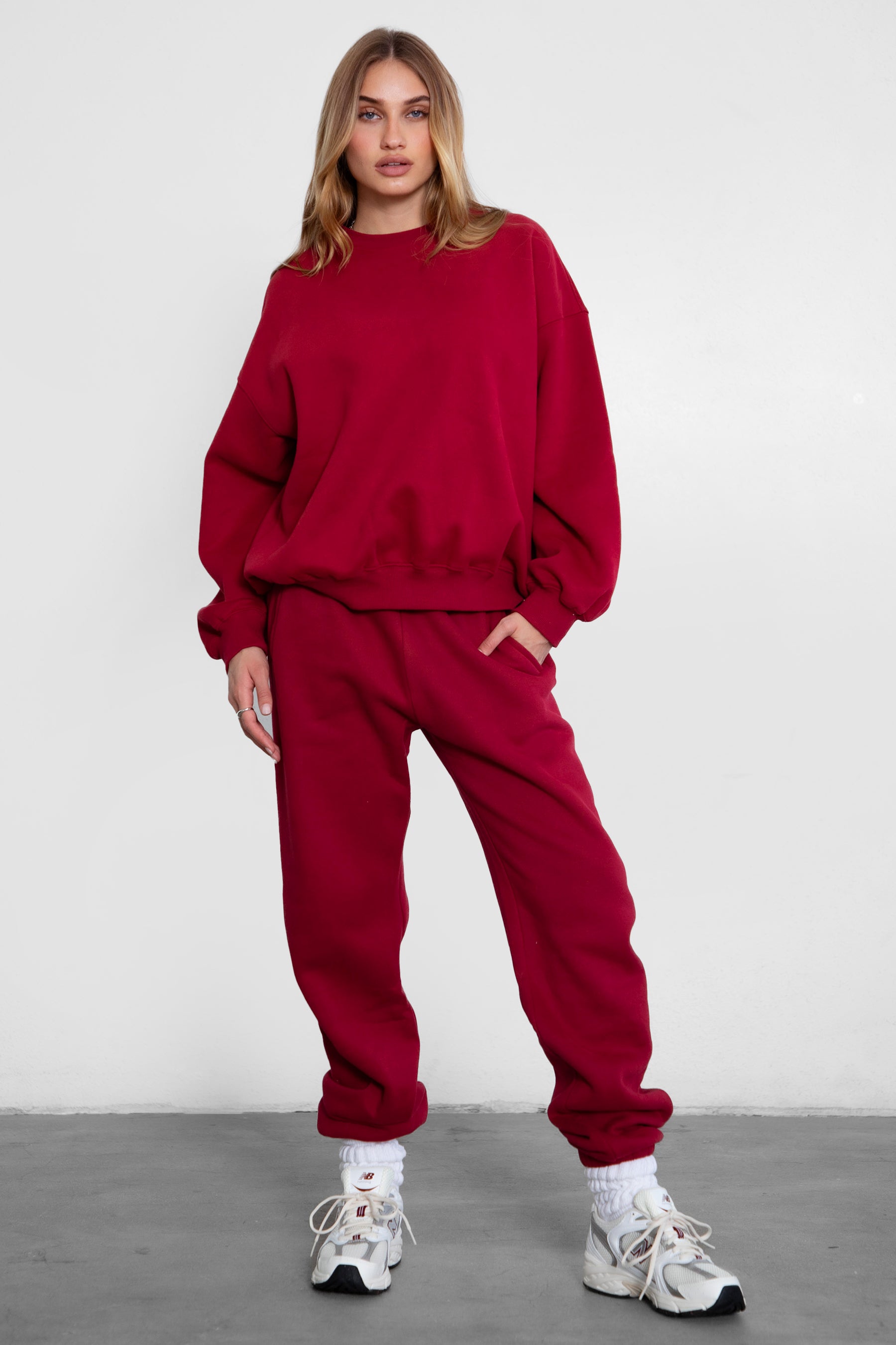 Woman wearing the TIC TOC TH28243 VARSITY burgundy fleece crew neck pullover sweatshirt featuring dropped shoulders, ribbed trim, and plush fleece fabric with the matching bottoms 