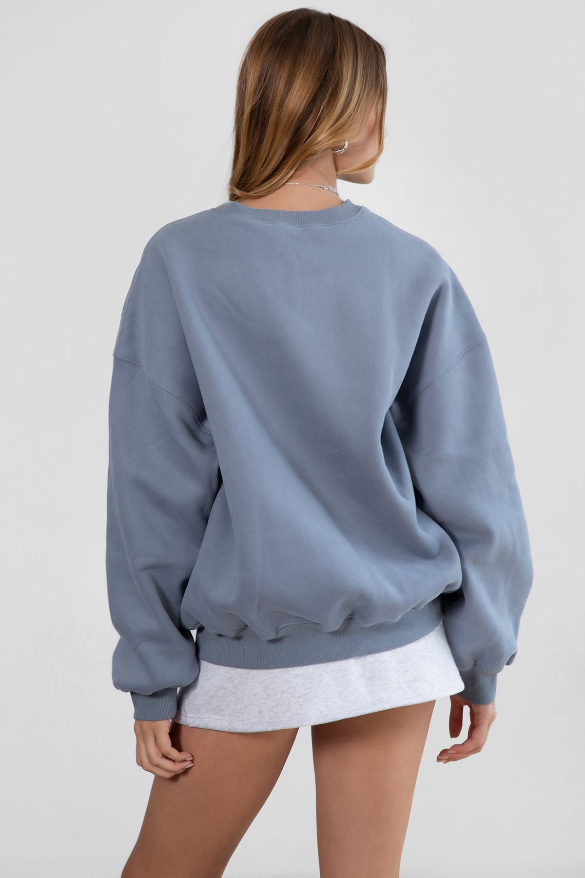 Woman wearing the TIC TOC TH28243 VARSITY french blue fleece crew neck pullover sweatshirt featuring dropped shoulders, ribbed trim, and plush fleece fabric with the matching bottoms 