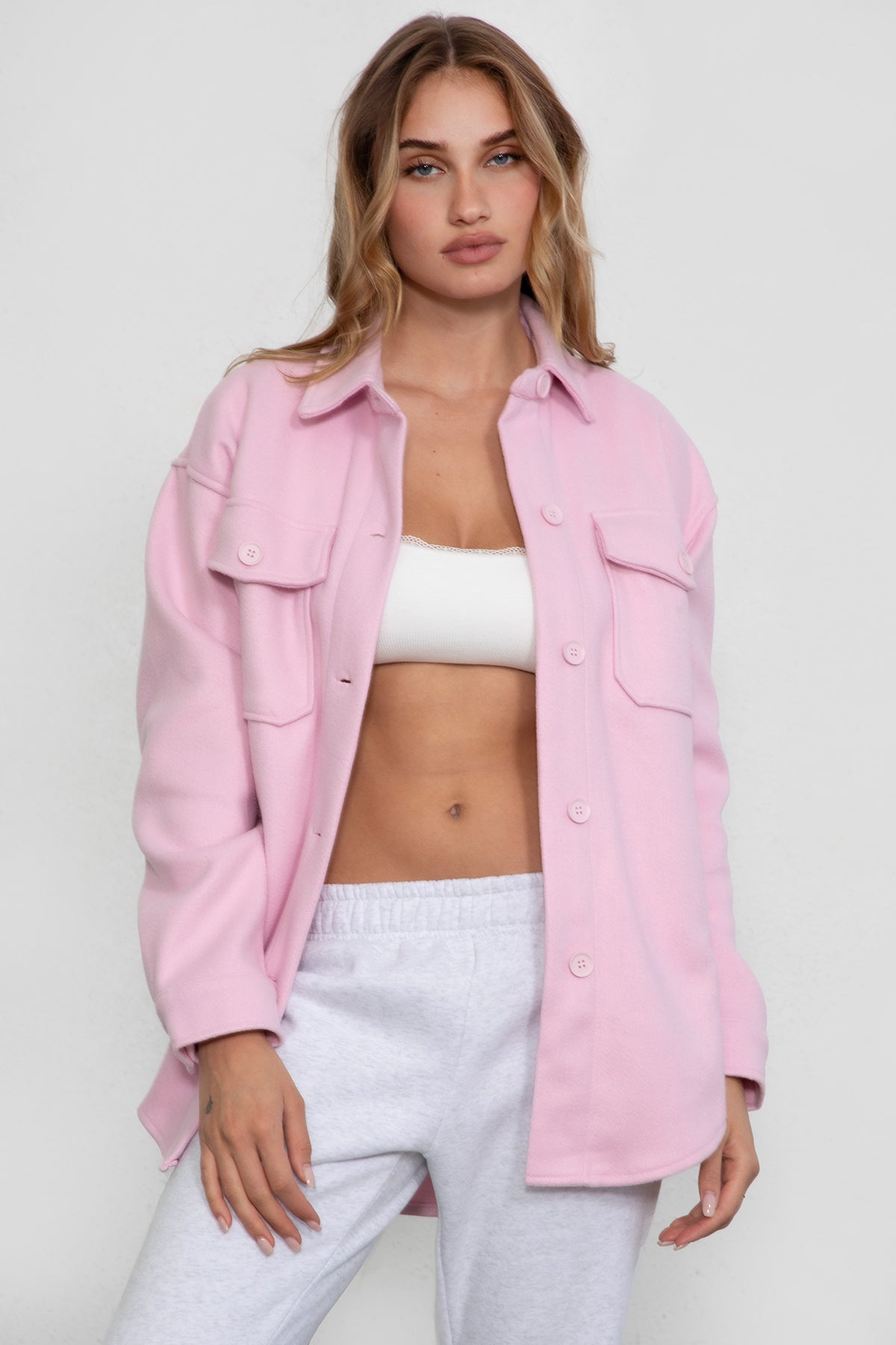 Woman wearing TIC TOC TH29148 BIRKEN faux wool oversized shirt shacket with button front and double pockets in color blush pairedwith lounge top and sweats