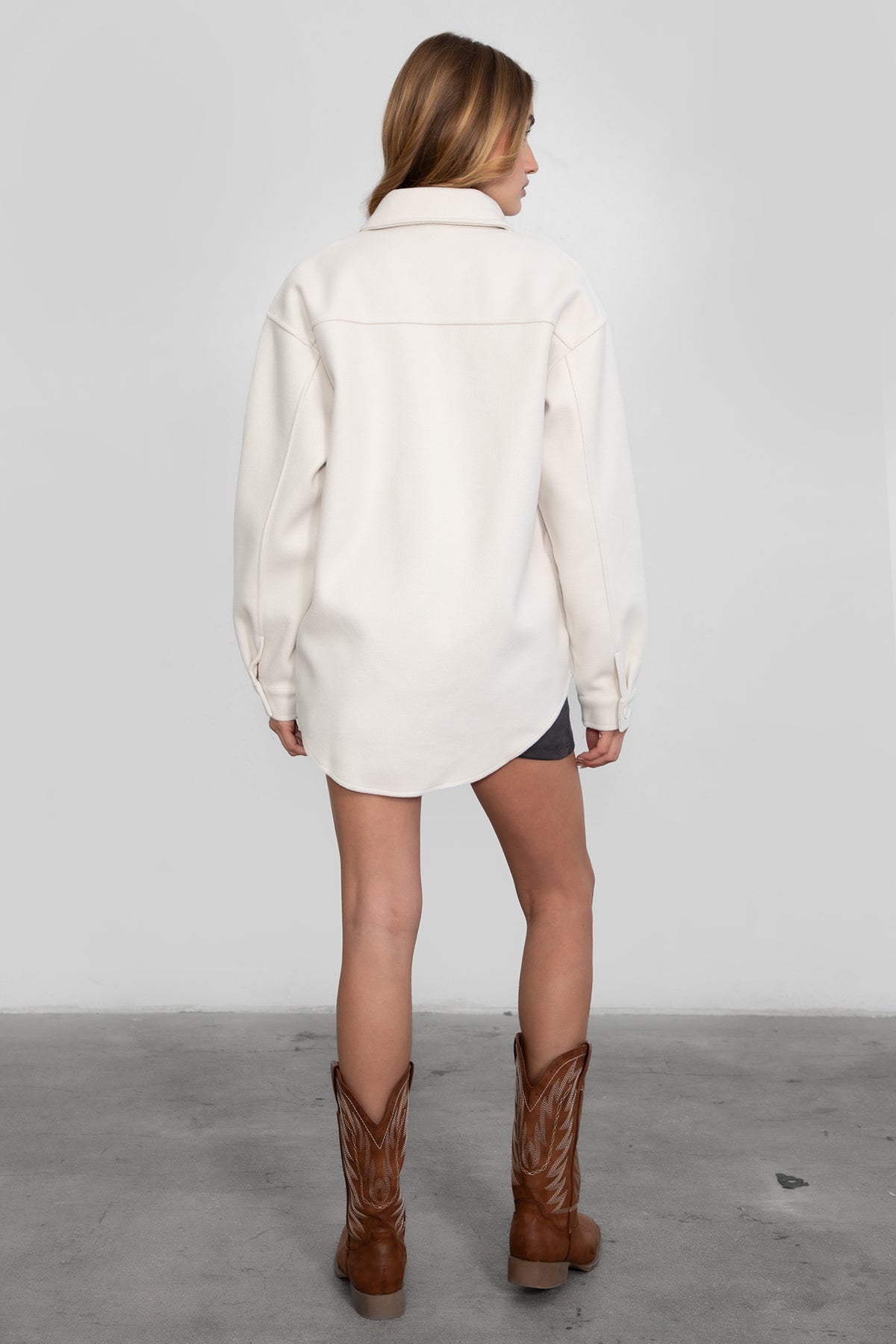 Woman wearing TIC TOC TH29148 BIRKEN faux wool oversized shirt shacket with button front and double pockets in color cream paired in a western way.