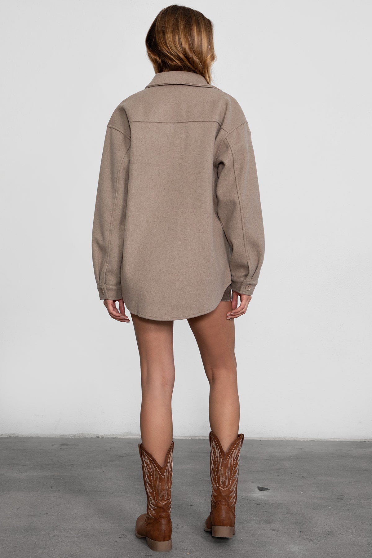 Woman wearing TIC TOC TH29148 BIRKEN faux wool oversized shirt shacket with button front and double pockets in color taupe paired with a brown mini skirt