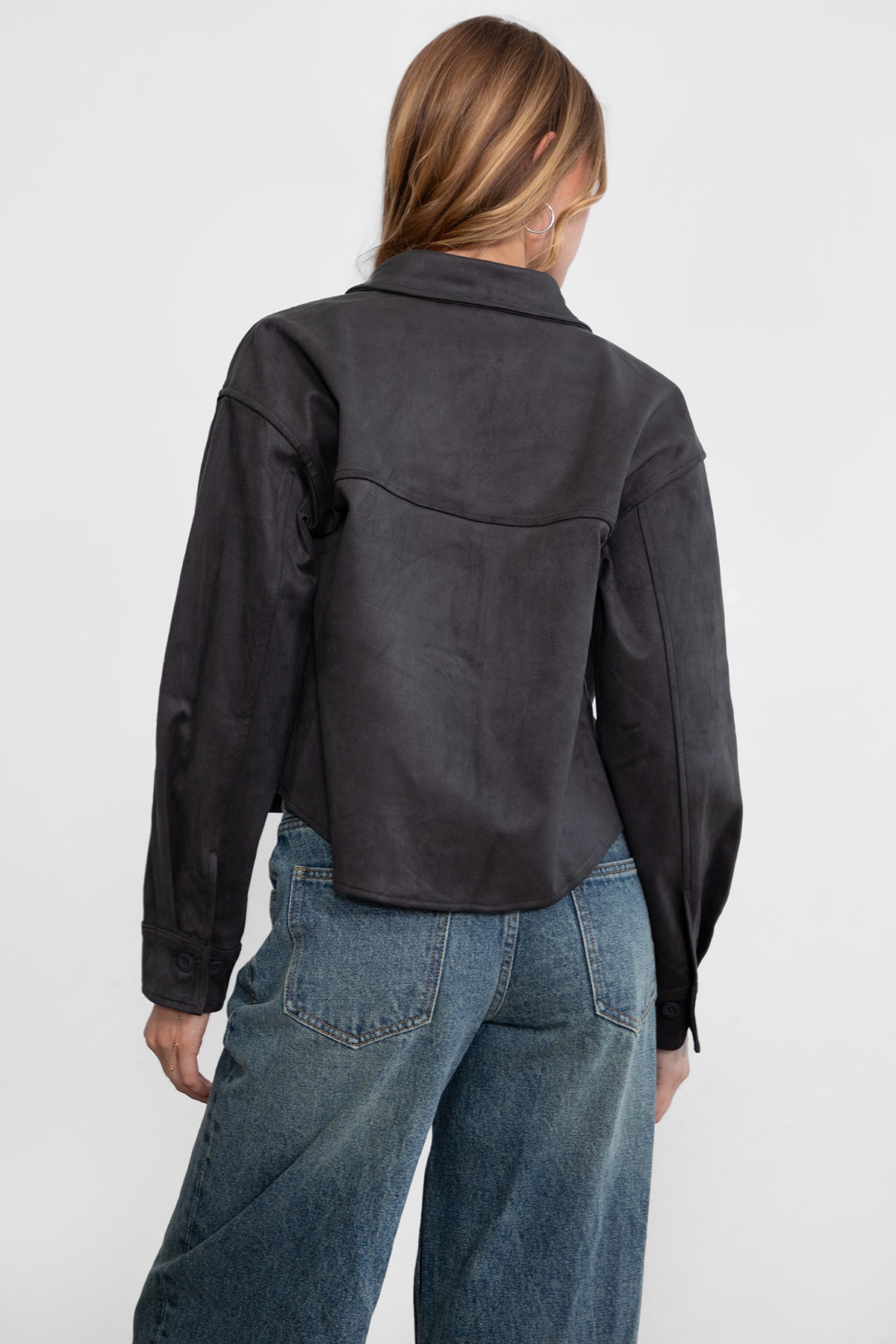Woman wearing TIC TOC TH29341 LORIA faux suede cropped shacket with collared neckline and button front design inc harcoal paired with denim jeans. 