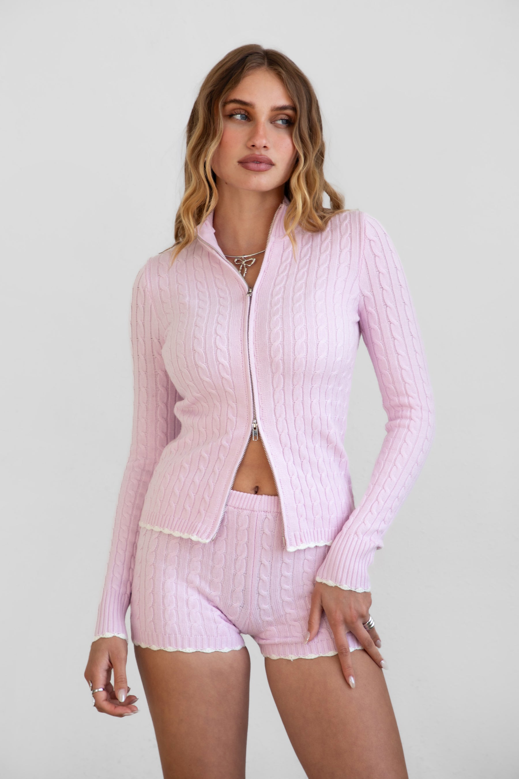 Woman wearing TIC TOC TPC31027 CLINE cable knit two piece lounge set with zip up mock neck sweater and matching shorts in color blush 