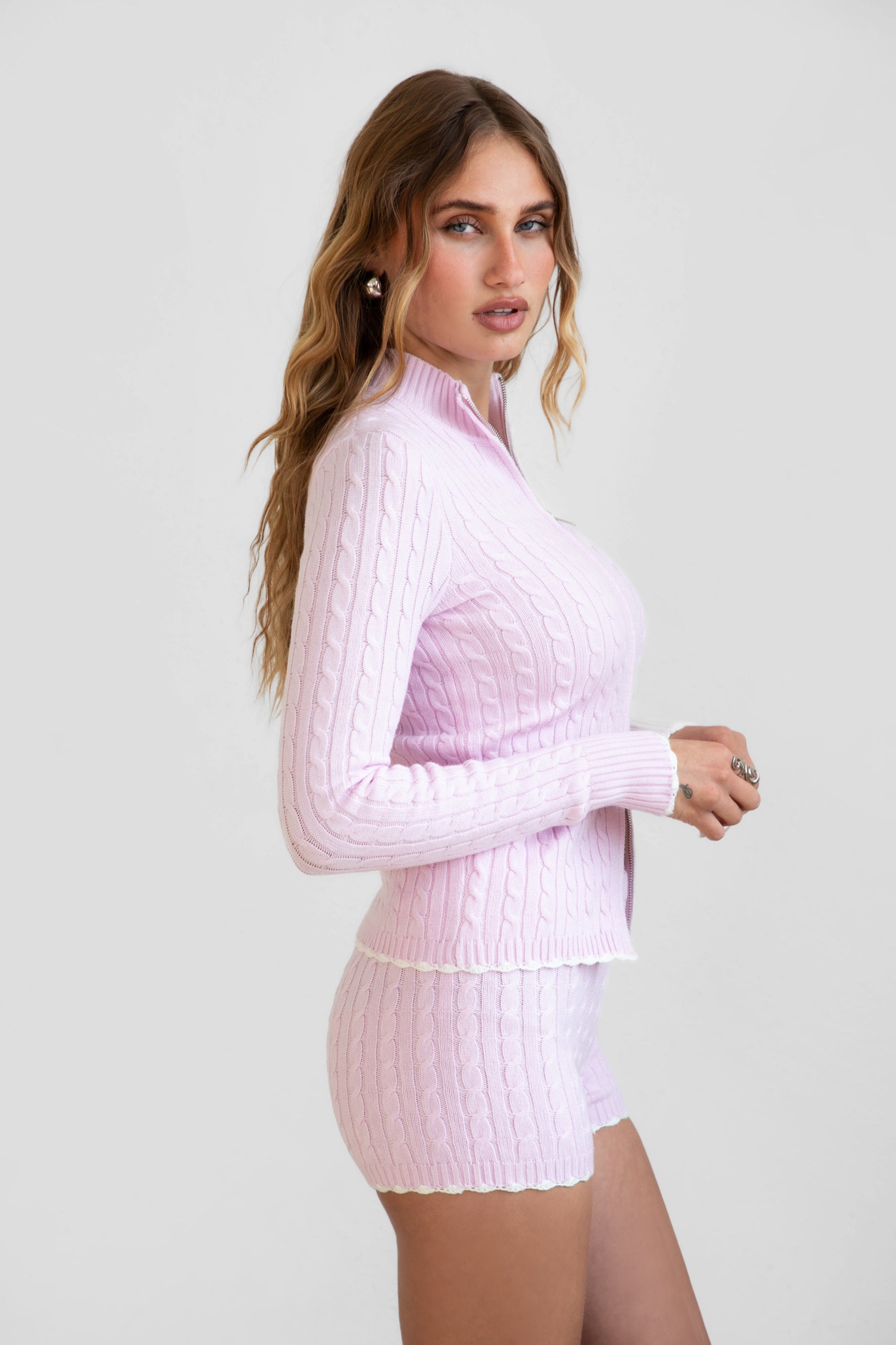Woman wearing TIC TOC TPC31027 CLINE cable knit two piece lounge set with zip up mock neck sweater and matching shorts in color blush 